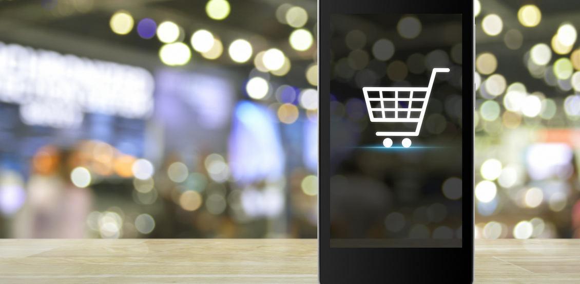 Shopping cart Icon on smart phone screen over blur mall