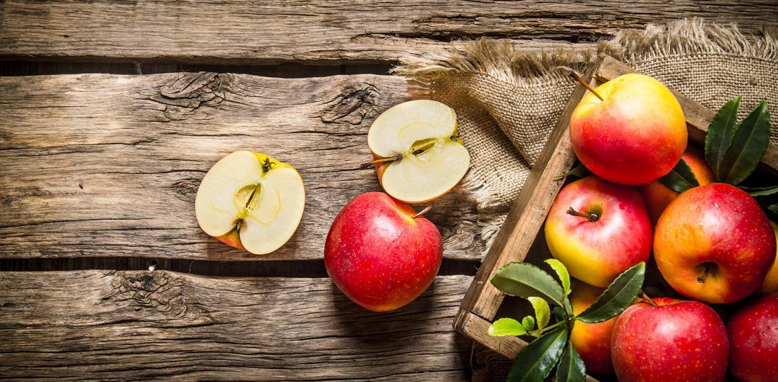 Fresh red apples in wooden box.