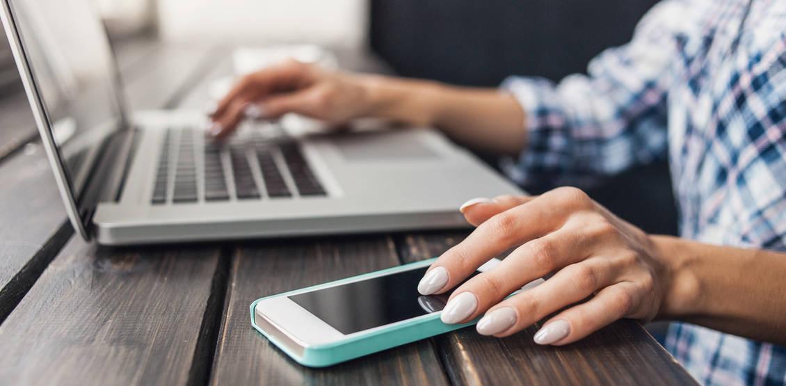 Woman using smart phone and laptop computer