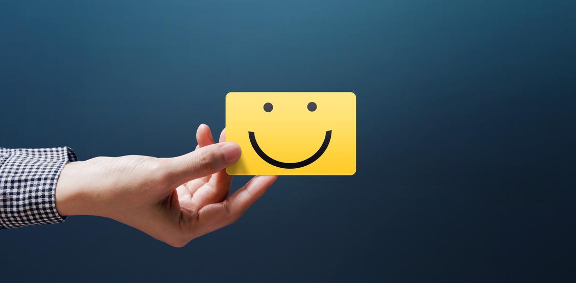 Person's hand with a happy face business card